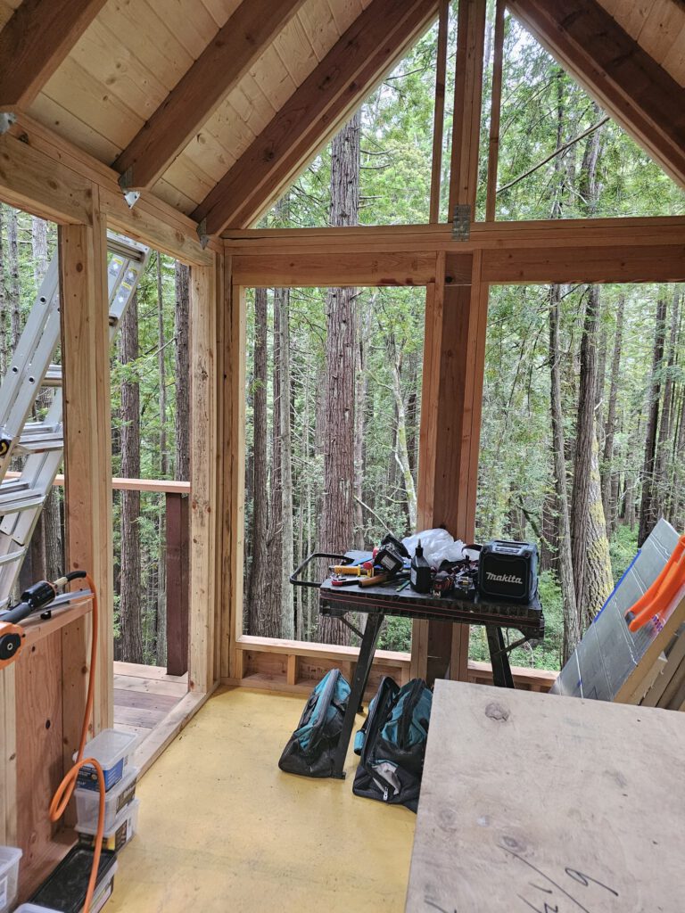 Roof decking installed. Beautiful 2x6 white pine boards with tongue-and-groove sides that contrast well with the darker redwood rafters.