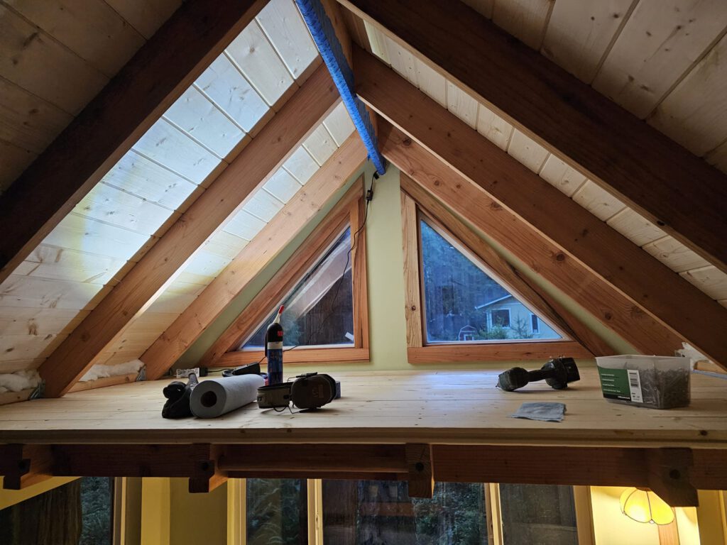 Loft base installed. I still needed to make end-boxes at the left and right ends to frame a full-size mattress. The blue band is painter's tape holding a strip light that I had glued in.